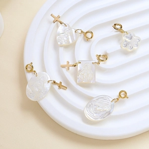 Macro detail of mother-of-pearl charms with religious relief and gold cross accents