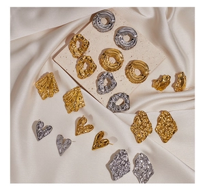 Detailed view of irregular geometric earrings with hammered metal texture in gold and silver