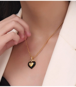 Detail shot of heart-shaped enamel pendant necklace with diamonds on female model