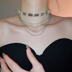 Détail d'un collier ras de cou argenté multicouche avec perles et chaînes délicates