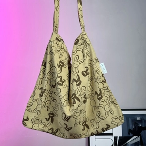 Detail of corduroy tote bag showing beige texture and dark brown rabbit print