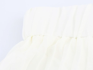 Close-up detail of white pleated chiffon skirt showing elastic waistband texture
