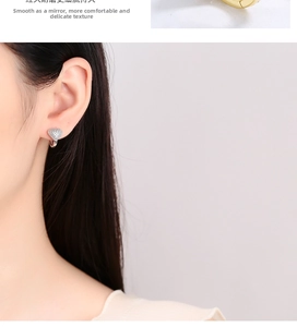 Detail view of heart-shaped pavé earrings and a model wearing the silver jewelry