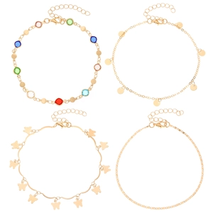 Detail of four gold anklets with colorful gems, butterfly charms, and flat chain links
