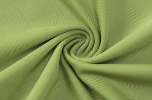 Macro shot of grass green ribbed knit fabric showing soft texture and elastic weave