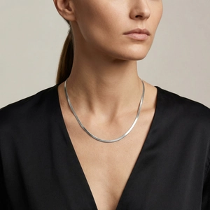 Silver flat snake chain necklace worn by a model on a clean minimalist background