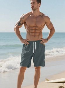 Detail of dark grey quick-dry men's swim trunks with white drawstrings on the beach