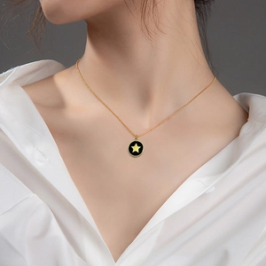 Collier en acier titane avec pendentif étoile en nacre noire porté par un mannequin