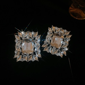 Detailed macro view of square earrings with champagne gemstones and diamond-like accents