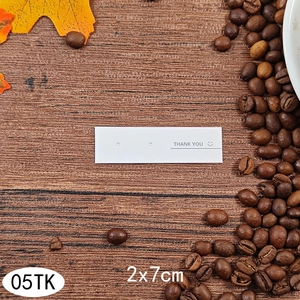White earring display cards measuring 2x7cm with Thank You text on dark wood background
