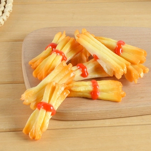 Realistic French fries hair clip with red ketchup band on a wooden tray background