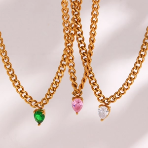 Close-up of gold Cuban link necklaces with green pink and white heart-shaped zircons