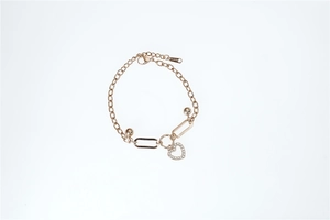Close-up of rose gold chain bracelet featuring a heart-shaped zircon pendant and bead charms