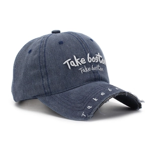 Detail of distressed navy denim baseball cap with Take Boston white embroidery and frayed brim