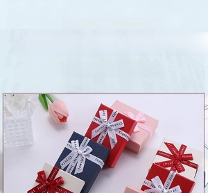 Detail of cross-textured jewelry gift box with silk ribbon bow and lid-off structure