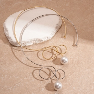 Minimalist twisted metal collar necklace with large white pearls in gold and silver finish