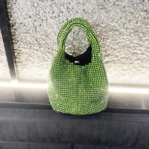 Close-up of emerald green rhinestone bucket bag with sparkling crystals and silver clasp