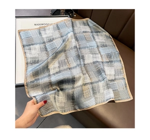 Detailed view of striped silk square scarf showing luxurious grey checkered pattern