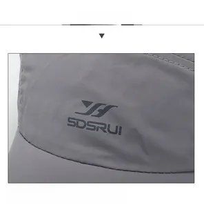 Detailed macro of dark grey quick-dry mesh fabric with bird logo on athletic sun hat