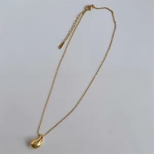 Detail of gold water drop pendant necklace with adjustable chain and lobster clasp