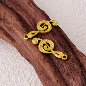 Golden G-clef musical note pendants in 304 stainless steel on a rustic wooden background