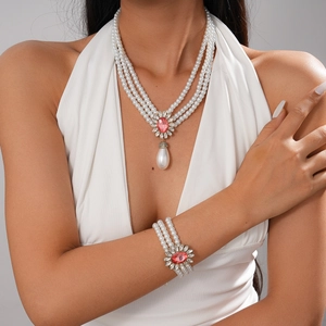 Baroque multilayer pearl jewelry set with pink crystal flower pendant on a white dress