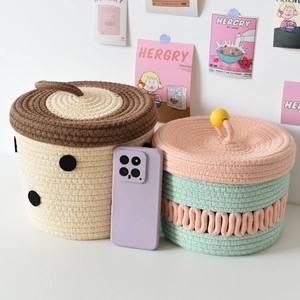 Detail of two woven cotton rope baskets with lids showing intricate texture and size scale
