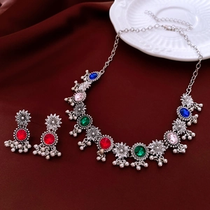 Detail of vintage silver necklace set with multi-color rhinestones and floral charms