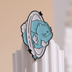 Cute enamel cat planet brooch with blue stars and clouds on white stone background