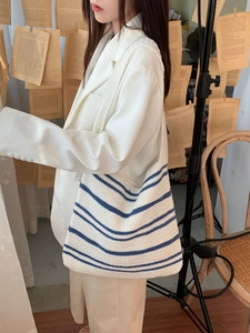 Minimalist white knitted tote bag with blue horizontal stripes and woven shoulder strap