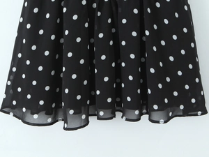 Detail weißer Polka Dots auf schwarzem Chiffonstoff mit Textur und elegantem Faltenwurf