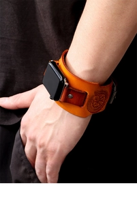 Close-up of brown leather wide cuff Apple Watch strap with vintage Viking compass embossing