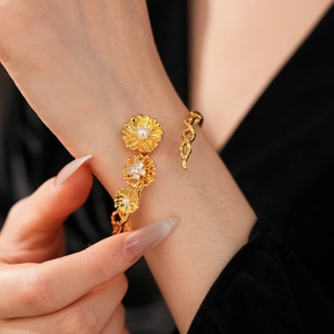 Detail of vintage gold flower bracelet with pearls and zircons worn on a wrist