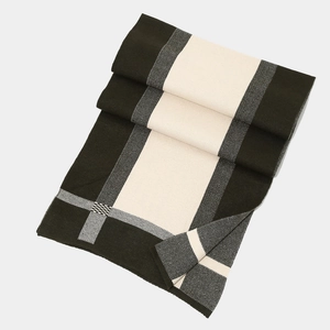 Detail of black and white checkered knit scarf with soft geometric block pattern