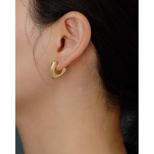 Close-up of elegant gold heart-shaped hoop earrings worn by a model in s925 silver