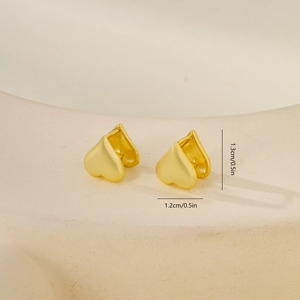 Vue macro des boucles d'oreilles cœur en or mat avec dimensions de 1,2 cm par 1,3 cm