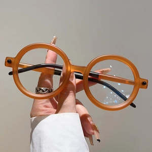 Détail des lunettes de soleil rondes vintage avec monture ambre translucide et branches
