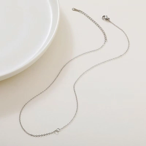 Collier chaîne serpent en acier inoxydable argenté avec fermoir mousqueton sur plateau blanc