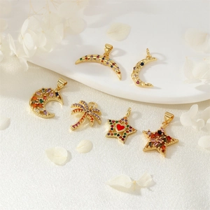 Gold pendants with colorful zircon in moon, star, and palm tree shapes on white fabric