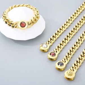Gold-plated curb chain necklaces with varied gemstone clasps on a clean pedestal display