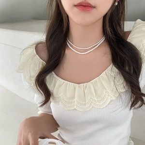 Close-up of double-layer pearl necklace on neck showing elegant French retro style