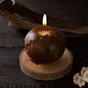 Macro shot of 3D globe candle with detailed map relief on a rustic wood base
