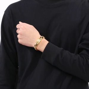Close-up of a 14mm gold Cuban link bracelet with sparkling rhinestones on male wrist