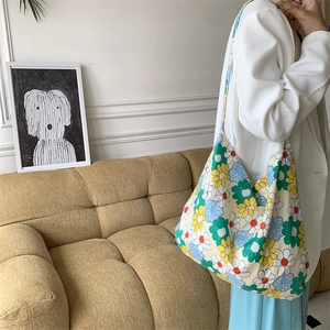 Detail of a large floral canvas tote bag showing the colorful daisy prints and spacious interior