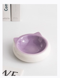 Overhead view of minimalist cat-ear ceramic bowl with purple interior and white exterior