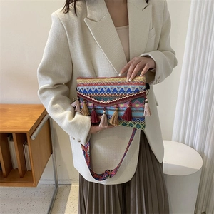 Close-up of bohemian woven crossbody bag with colorful patterns and tassel details