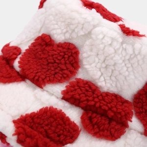 Macro shot of plush red and white heart pattern fleece fabric showing soft texture