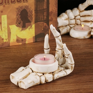 Gothic skull hand resin candle holder with pink tea light on rustic wooden background