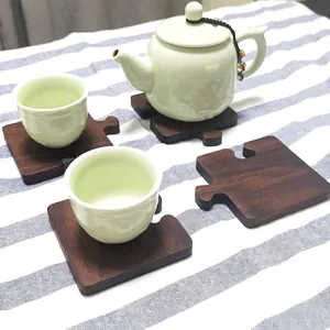 Set of 4 walnut wood coasters with puzzle design and natural grain on striped cloth