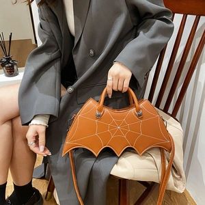 Brown leather bat-wing handbag featuring spider web embroidery and dual-use straps